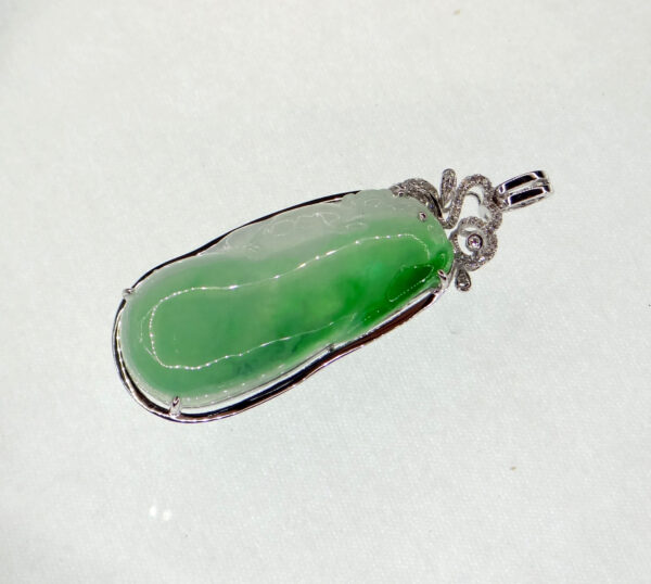 A stunning ice-green natural emerald pendant carved into a melon shape, symbolizing good fortune. The 18K gold clasp is delicately inlaid with diamonds, enhancing its luxurious appeal.