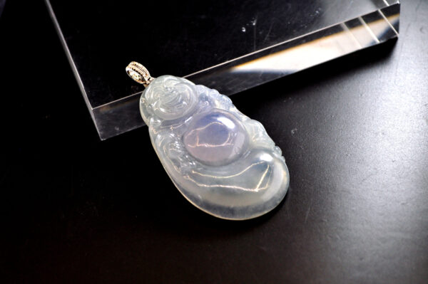 A stunning Natural Ice-type Violet Jadeite Laughing Buddha Pendant, featuring a meticulously carved laughing Buddha with a kind expression and smooth, natural lines. The 18K gold and diamond clasp adds a touch of luxury, making it a perfect blend of traditional craftsmanship and modern elegance.