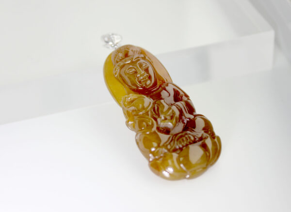 A beautifully carved Natural Yellow Jadeite Avalokitesvara Pendant featuring warm amber-like hues and intricate detailing, elegantly set with an 18K white gold and diamond clasp.