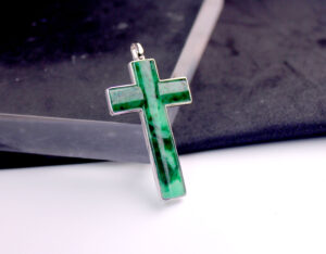 A stunning close-up of the Natural Flower Jade Cross Pendant in 18K white gold, showcasing its intricate green hues and natural dark veins, elegantly set in a polished white gold frame.