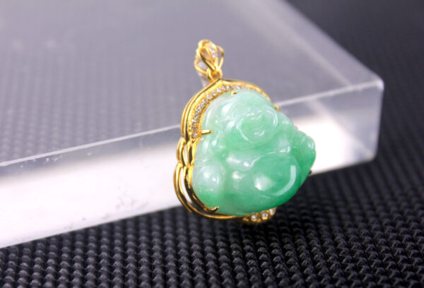 A stunning close-up of the Natural Ice-Green Jadeite Seated Buddha Pendant, showcasing its translucent jadeite, intricate hand-carved details, and sparkling diamond accents set in luxurious 18K yellow gold.