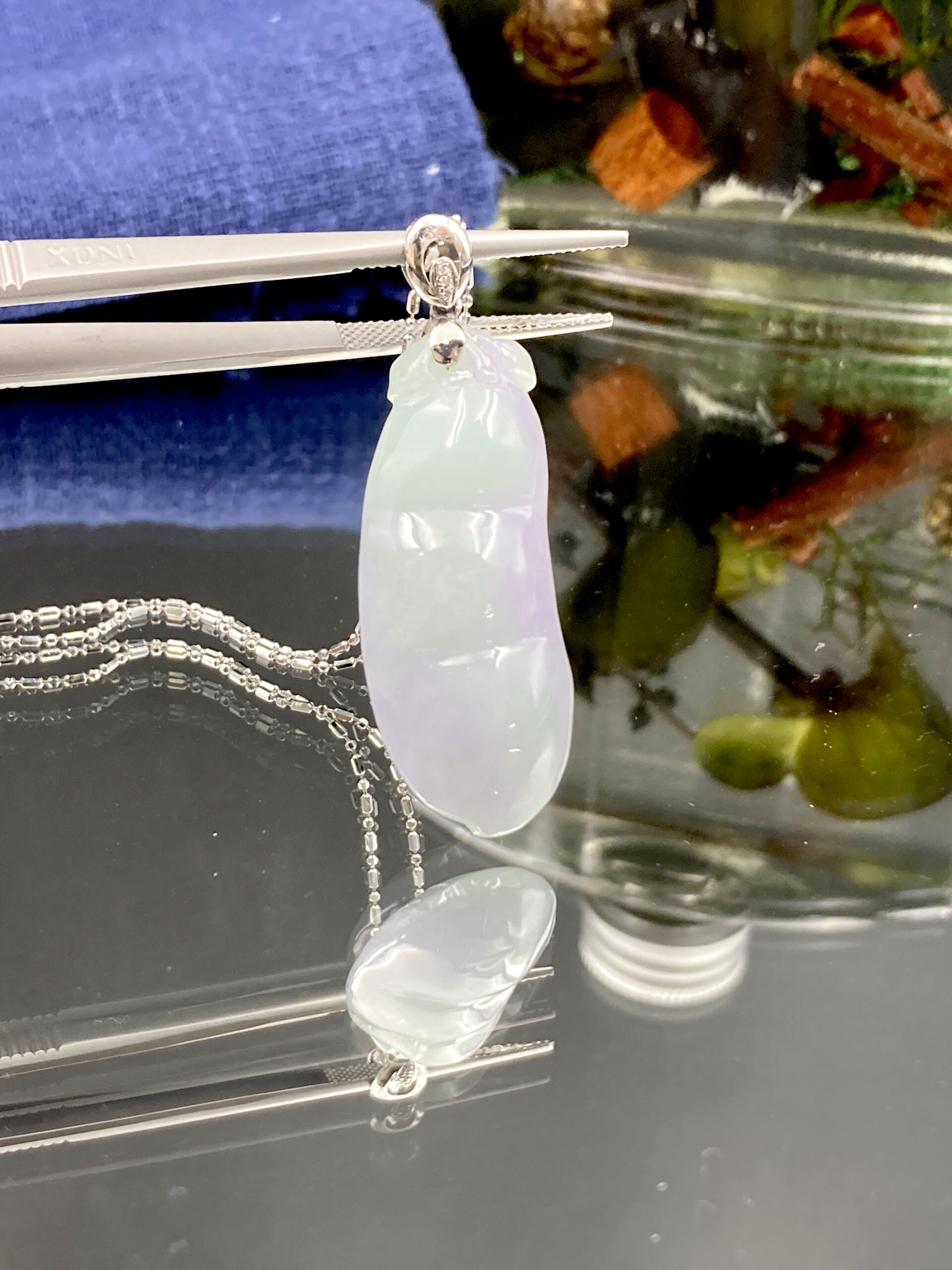 A stunning close-up of the Natural Spring-with-Color Jadeite Bean Pendant, showcasing its ice-type clarity, delicate purple-green hues, and intricate 18K white gold diamond clasp.