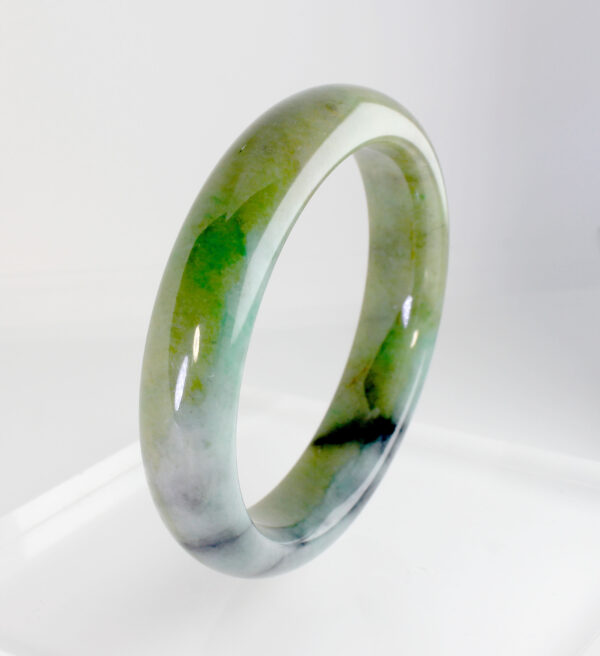 A stunning close-up of the Natural Three-Color Jadeite Bracelet, showcasing its seamless blend of green, yellow, and white hues. The polished, round beads glisten softly, reflecting the artistry of traditional jade-carving techniques.