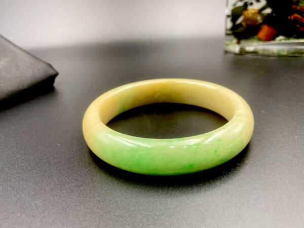 A stunning Natural Yellow-and-Green Jadeite Bracelet with seamless color transitions, delicate texture, and classic round-bar design, showcasing the elegance of untreated Grade-A jadeite.