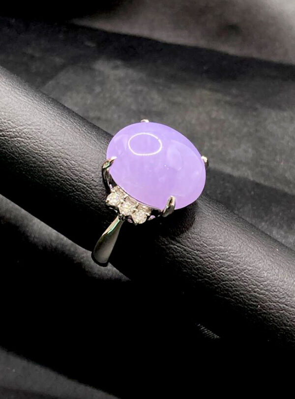A stunning close-up of the Natural Ice-type Violet Jadeite Cabochon Ring, featuring a lustrous violet jadeite centerpiece set in gleaming platinum with delicate diamond accents. The cabochon cut highlights the jade's translucent glow, while the platinum band adds a touch of modern sophistication.