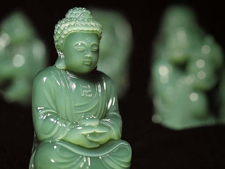 A craftsman carving a large Xiuyan jade sculpture, demonstrating traditional jade-working techniques.