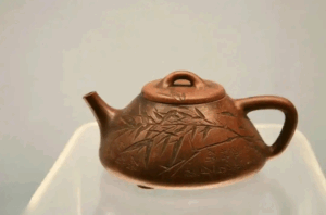 Rear angle of authentic zisha teapot displaying master craftsman's seal mark and natural tea-stained patina from centuries of use