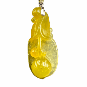 A stunning icy yellow jadeite pendant carved into a delicate magnolia flower, showcasing intricate details and a smooth, lustrous finish. Paired with an 18K gold diamond clasp for added elegance.