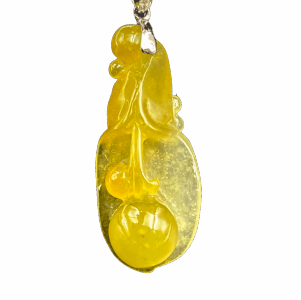 A stunning icy yellow jadeite pendant carved into a delicate magnolia flower, showcasing intricate details and a smooth, lustrous finish. Paired with an 18K gold diamond clasp for added elegance.