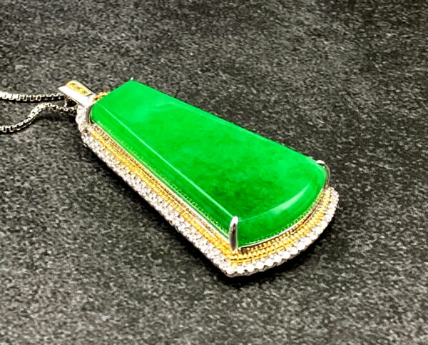 A stunning natural ice-type jadeite pendant with vibrant green color, finely polished and set in luxurious 18K gold (white/yellow) with diamond embellishments, showcasing elegance and sophistication.