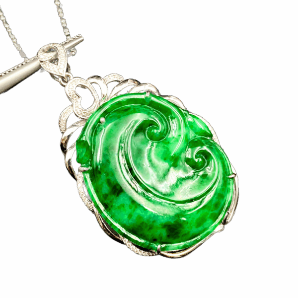 A stunning Flower Green Jadeite Pendant featuring swirling natural patterns, set in 18K white gold with sparkling diamond accents. The heart-shaped clasp adds a delicate touch, making it a versatile accessory for any outfit.