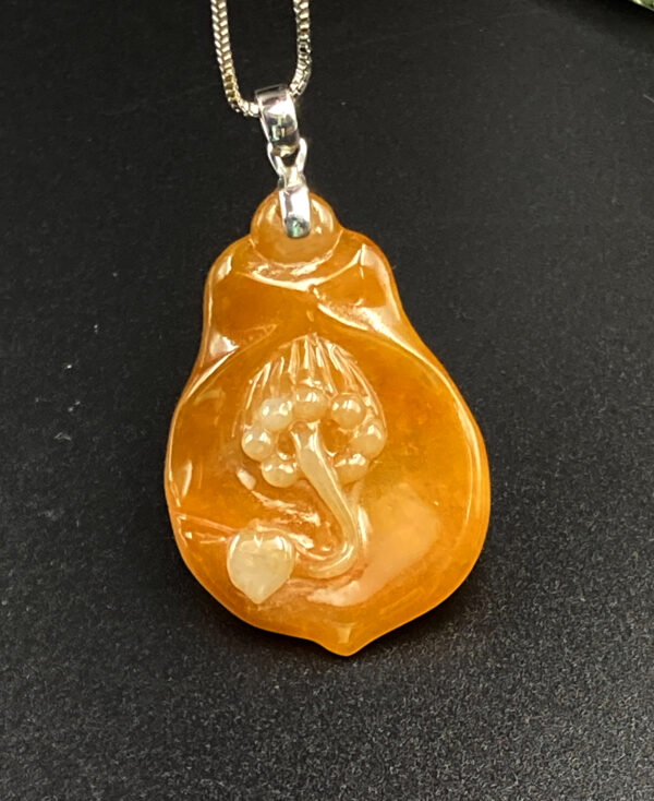 A stunning close-up of the Natural Ice Yellow Jadeite Magnolia Pendant, showcasing its warm golden hue, delicate floral carving, and sleek 18K white gold clasp on a neutral background.