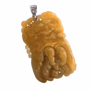 A stunning close-up of the Natural Yellow Jadeite Buddha's Hand Pendant, showcasing its rich amber-yellow hue, intricate carving details, and the elegant 18K white gold clasp. The pendant rests on a soft velvet background, highlighting its lustrous texture.