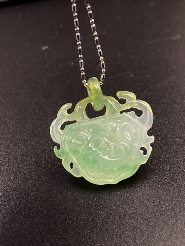 A stunning close-up of the Yellow and Green Jadeite Ruyi Pendant, showcasing its translucent icy jadeite with blended yellow and green tones. The intricate ruyi carving and polished metal chain highlight its elegance and craftsmanship.