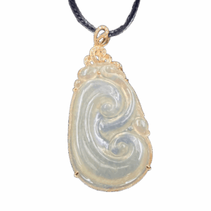 A stunning close-up of the Natural Ice-white Jade Ruyi Pendant, showcasing its delicate 18K yellow gold inlay and intricate Ruyi carving. The jade's translucent, ice-like sheen contrasts beautifully with the warm gold tones.