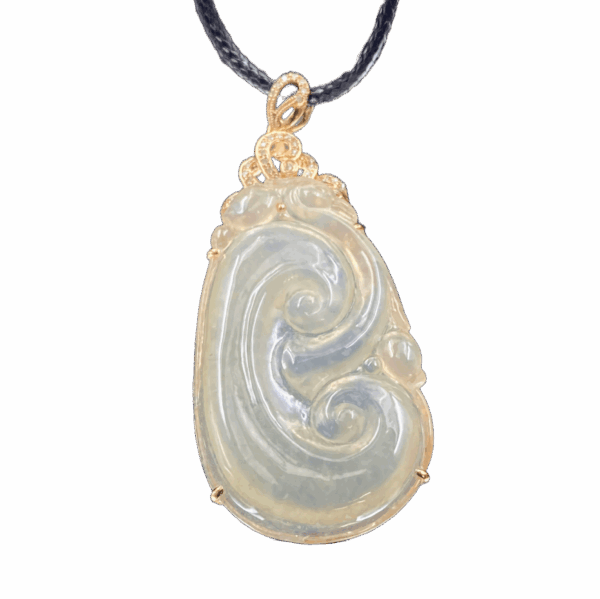 A stunning close-up of the Natural Ice-white Jade Ruyi Pendant, showcasing its delicate 18K yellow gold inlay and intricate Ruyi carving. The jade's translucent, ice-like sheen contrasts beautifully with the warm gold tones.