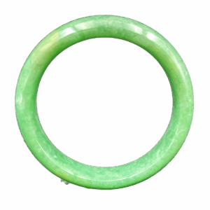 A stunning close-up of a smooth, glossy apple-green jadeite bangle resting on a velvet surface, showcasing its uniform color and flawless craftsmanship.