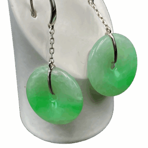 A pair of elegant Ice-Type Jadeite Bean-Green Earrings, showcasing the natural translucency and fine texture of the jadeite. The smooth, polished "Ping An Kou" pendant is securely set in sleek 18K white gold, with a minimalist hook and chain design. The earrings rest gracefully against a neutral background, highlighting their delicate green hue and refined craftsmanship.