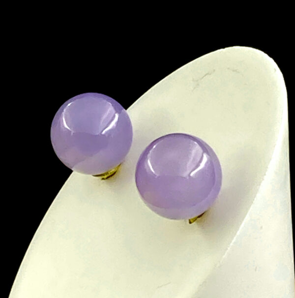 A pair of elegant violet jadeite stud earrings, set in lustrous 18K yellow gold, showcasing the translucent purple hue and smooth polish of high-quality icy-type jadeite. Perfect for adding a touch of oriental sophistication to any outfit.