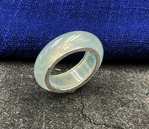 A stunning close-up of the Natural High-Ice Emerald Ring, showcasing its clear, icy emerald centerpiece set in lustrous 18K white gold. The smooth circular band and gemstone reflect light beautifully, highlighting its refined craftsmanship.