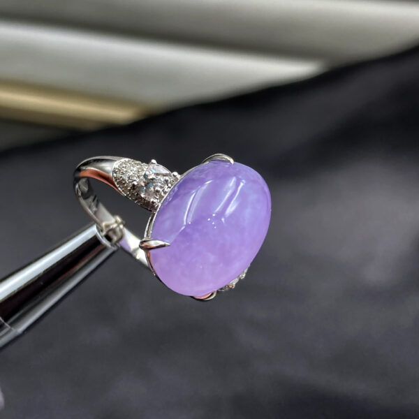 A stunning oval cabochon violet jadeite ring, showcasing vivid color and excellent transparency, set in 18K white gold with sparkling sapphires and diamonds.