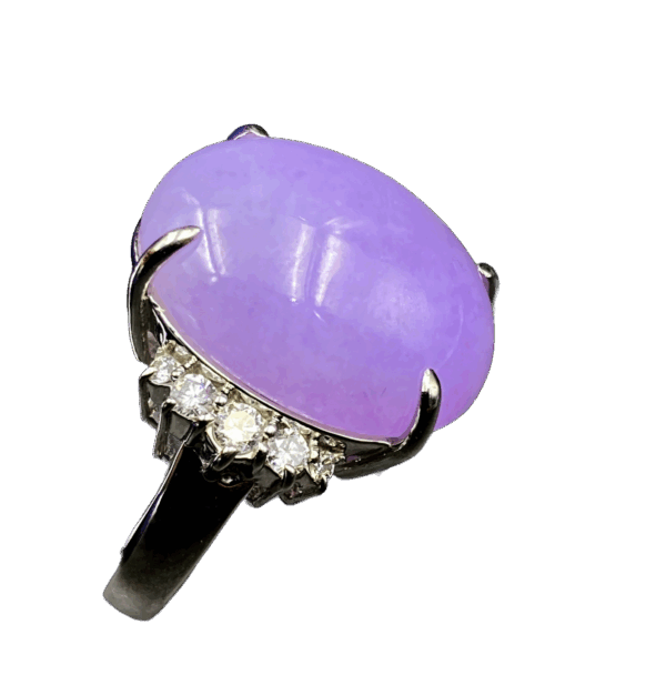 A stunning oval-shaped ice-type violet jadeite cabochon ring, set in lustrous platinum and accented with sparkling diamonds, showcasing timeless elegance.