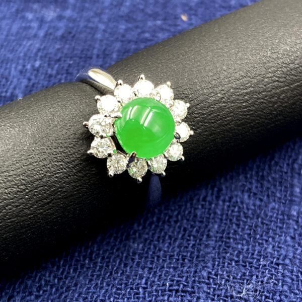 A stunning close-up of a vibrant full-green jadeite cabochon ring, elegantly set in platinum and surrounded by sparkling diamonds, showcasing its rich color and luxurious craftsmanship.