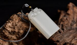 Imperial white jade pendant with intricate dragon motif, Qing Dynasty. Showcases perfect craftsmanship with visible 'mutton fat' texture symbolizing purity in Confucian philosophy.