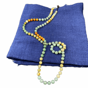 A delicate three-color jadeite bead bracelet featuring smooth, polished beads in green, yellow, and orange hues, strung on a durable brown cord for a refined and natural look.