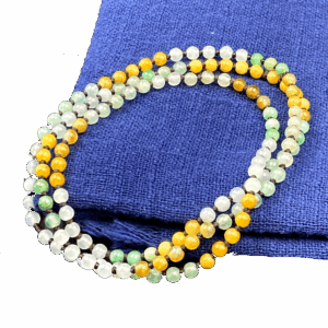 A stunning close-up of the Natural Ice-Type Jadeite Three-Color Necklace, showcasing its delicate 5.3 mm beads in rare yellow, green, and white hues. The smooth, polished surface reflects light beautifully, highlighting the traditional rope-knotting technique.