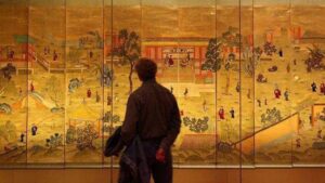 Professor Huang Jun’s new book Art Market: Consumption and Finance displayed beside Shanghai’s ART021 fair scene—symbolizing China’s evolving art consumption and finance ecosystem.