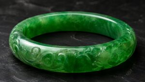 Translucent green jadeite pendant with gold clasp on velvet under gentle light
