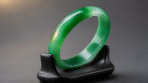 Translucent green jadeite bangle on dark velvet, soft dramatic light