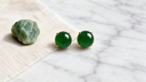 Translucent jadeite earrings on dark velvet under soft diffused light, elegant and serene