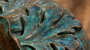 Close-up of an ancient Chinese bronze vessel with green patina, dramatic shadows, elegant luxury display